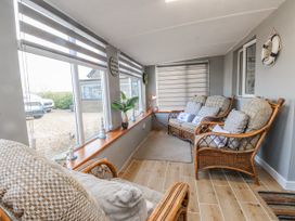 A conservatory with seating and plants at Hen Fecws Rhoshirwaun near Sarn Meyllteyrn