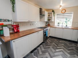 A kitchen with cabinets and a stove at Hen Fecws Rhoshirwaun near Sarn Meyllteyrn