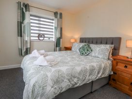 A bedroom with a bed and bedside tables at Hen Fecws Rhoshirwaun near Sarn Meyllteyrn