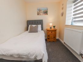 A bedroom with a single bed and side table at Hen Fecws Rhoshirwaun near Sarn Meyllteyrn