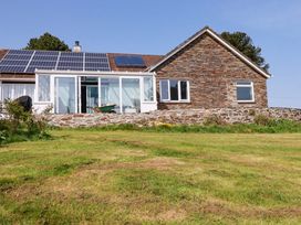 A house with solar panels and a wall at Tregoning in Lostwithiel