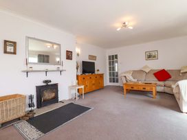A living room with a sofa, coffee table, and fireplace at Tregoning in Lostwithiel