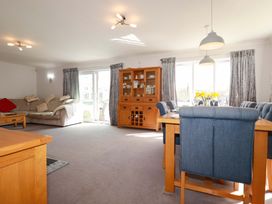 A living room with a sofa and dining area at Tregoning Lostwithiel