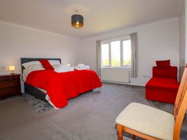 A bedroom with a bed and chair at Tregoning in Lostwithiel