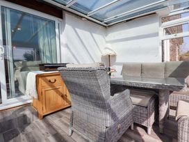 A conservatory with furniture and glass doors at Tregoning in Lostwithiel
