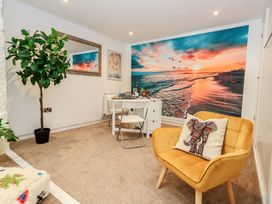 A living room with a table and chairs at Tipsy Turtle in Weymouth