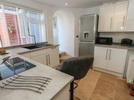 A kitchen with sink, stove, refrigerator, and bar stool at Tipsy Turtle in Weymouth