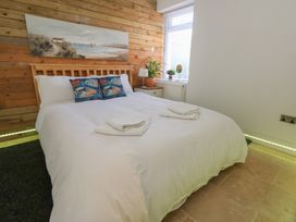A bedroom with a bed and bedside table at Tipsy Turtle in Weymouth