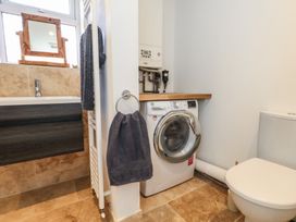 A bathroom with a washing machine and a sink at Tipsy Turtle in Weymouth