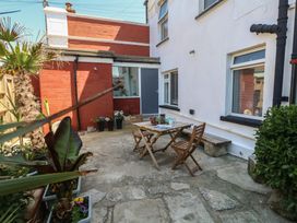 A garden with a table and chairs at Tipsy Turtle in Weymouth