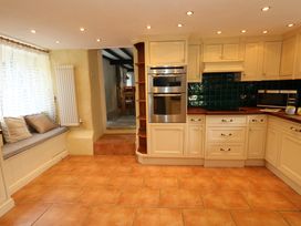 A kitchen with cabinets and appliances at Rose Cottage in Osmington