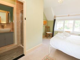 A bedroom with a bed and bathroom area at Rose Cottage in Osmington