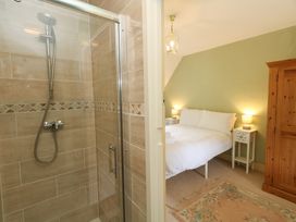 A bedroom with a bed and shower at Rose Cottage in Osmington