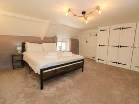 A bedroom with a bed and wardrobe at Rose Cottage in Osmington