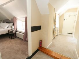 A bedroom with a bed and nightstand at Rose Cottage in Osmington