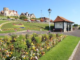 A flowerbed and a seating area at Rose Cottage in Osmington