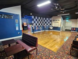 A game room with seating and arcade machines at Watersmeet - 85 @ Park Avenue Holiday Village Leysdown-On-Sea, Kent