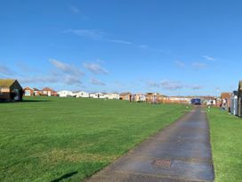 An outdoor area with mobile homes and a pathway at Watersmeet - 85 @ Park Avenue Holiday Village, Leysdown-On-Sea, Kent