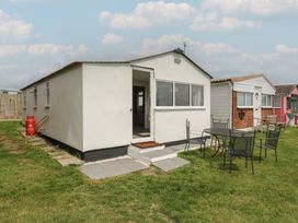 An outdoor view of a house with a table and chairs at Watersmeet - 85 @ Park Avenue Holiday Village Leysdown-On-Sea, Kent