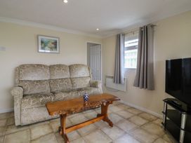 A living room with a sofa and a wooden table at Watersmeet - 85 @ Park Avenue Holiday Village, Leysdown-On-Sea, Kent