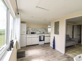 A kitchen with countertop and refrigerator at Watersmeet - 85 @ Park Avenue Holiday Village in Leysdown-On-Sea, Kent