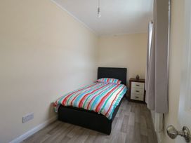 A bedroom with a bed and nightstand at Watersmeet - 85 @ Park Avenue Holiday Village, Leysdown-On-Sea, Kent