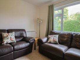 A living room with two sofas and a lamp at 2 North Road in Maiden Newton, Dorset