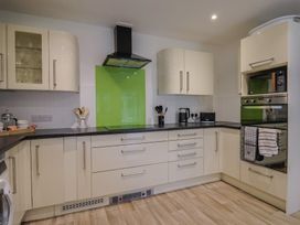 A kitchen with green backsplash and appliances at 2 North Road, Maiden Newton, Dorset