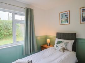 A bedroom with a bed and window at 2 North Road, Maiden Newton, Dorset