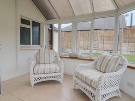 A conservatory with two rattan chairs and a table at 2 North Road, Maiden Newton, Dorset