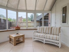 A conservatory with a sofa and a table at 2 North Road, Maiden Newton, Dorset