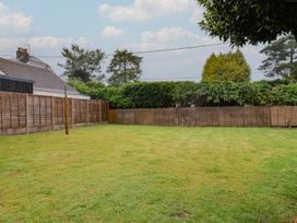 A garden with grass and fences at 2 North Road in Maiden Newton, Dorset