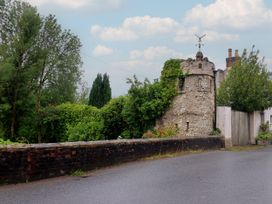 A tower covered in ivy next to a road at 2 North Road Maiden Newton, Dorset