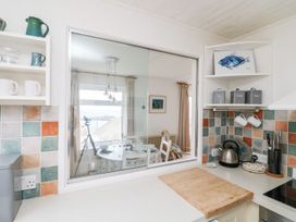A kitchen with a view towards a dining area at Wootton Gray in Penzance