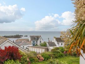A view of the sea and houses with flowers at Wootton Gray in Penzance