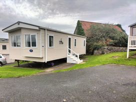A caravan with stairs on a grass area at Beverley Bay Holiday Park - Holiday Accommodation 333 Paignton