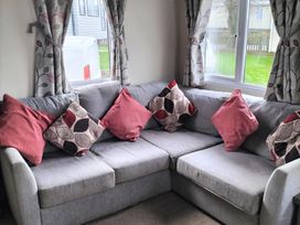 A living room with a sofa and cushions at Beverley Bay Holiday Park - Holiday Accommodation 333 Paignton
