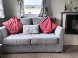 A living room with a sofa and cushions at Beverley Bay Holiday Park - Holiday Accommodation 333, Paignton