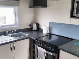 A kitchen with a sink and stove at Beverley Bay Holiday Park - Holiday Accommodation 333 Paignton