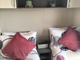 A bedroom with beds and decorative plants at Beverley Bay Holiday Park - Holiday Accommodation 333 in Paignton