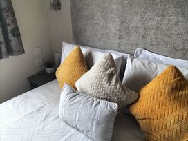 A bed with pillows and cushions at Beverley Bay Holiday Park - Holiday Accommodation 333 Paignton
