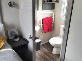 A bathroom with a toilet and towel rack at Beverley Bay Holiday Park - Holiday Accommodation 333, Paignton