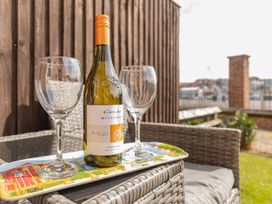 A wine bottle and glasses on a tray in an outdoor seating area at Rails End