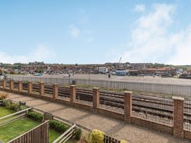 A view of a parking area and buildings from a property with a fence at Rails End