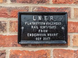 A metal sign mounted on a brick wall at Rails End
