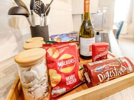 A kitchen countertop with snacks and a bottle of wine at Rails End