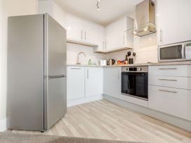 A kitchen with refrigerator, sink, kettle, and microwave at Rails End