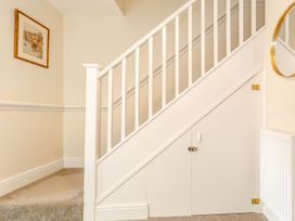 A staircase with a picture frame and a door under the stairs at Rails End