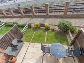 A patio with a table and chairs overlooking railway tracks at Rails End