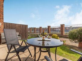 An outdoor patio with a table and chairs at Rails End 